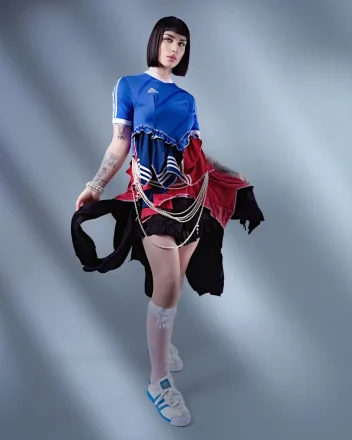 Fashion portrait featuring a sleek black bob haircut paired with a layered sports-inspired editorial outfit.