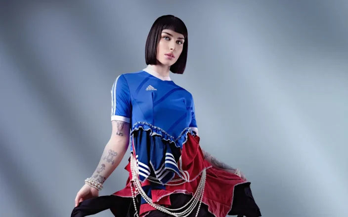 Fashion portrait featuring a sleek black bob haircut paired with a layered sports-inspired editorial outfit.