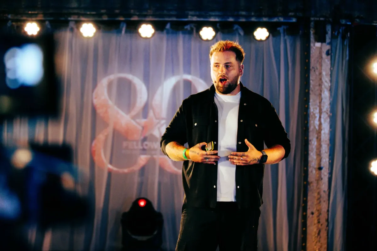 Jordan Heyes speaks on stage at an event.