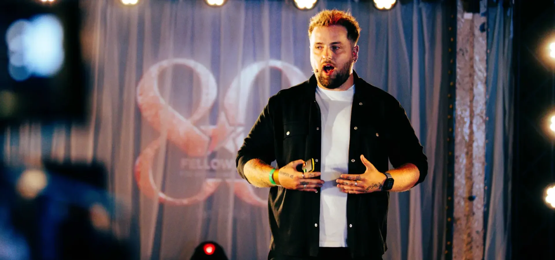 Jordan Heyes speaks on stage at an event.