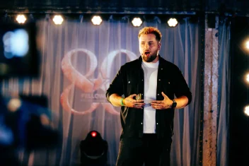 Jordan Heyes speaks on stage at an event.