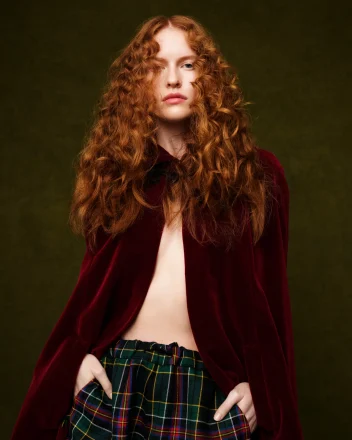 Fashion portrait featuring long, voluminous copper curls inspired by 80s hair trends, styled with texture, movement and editorial flair.