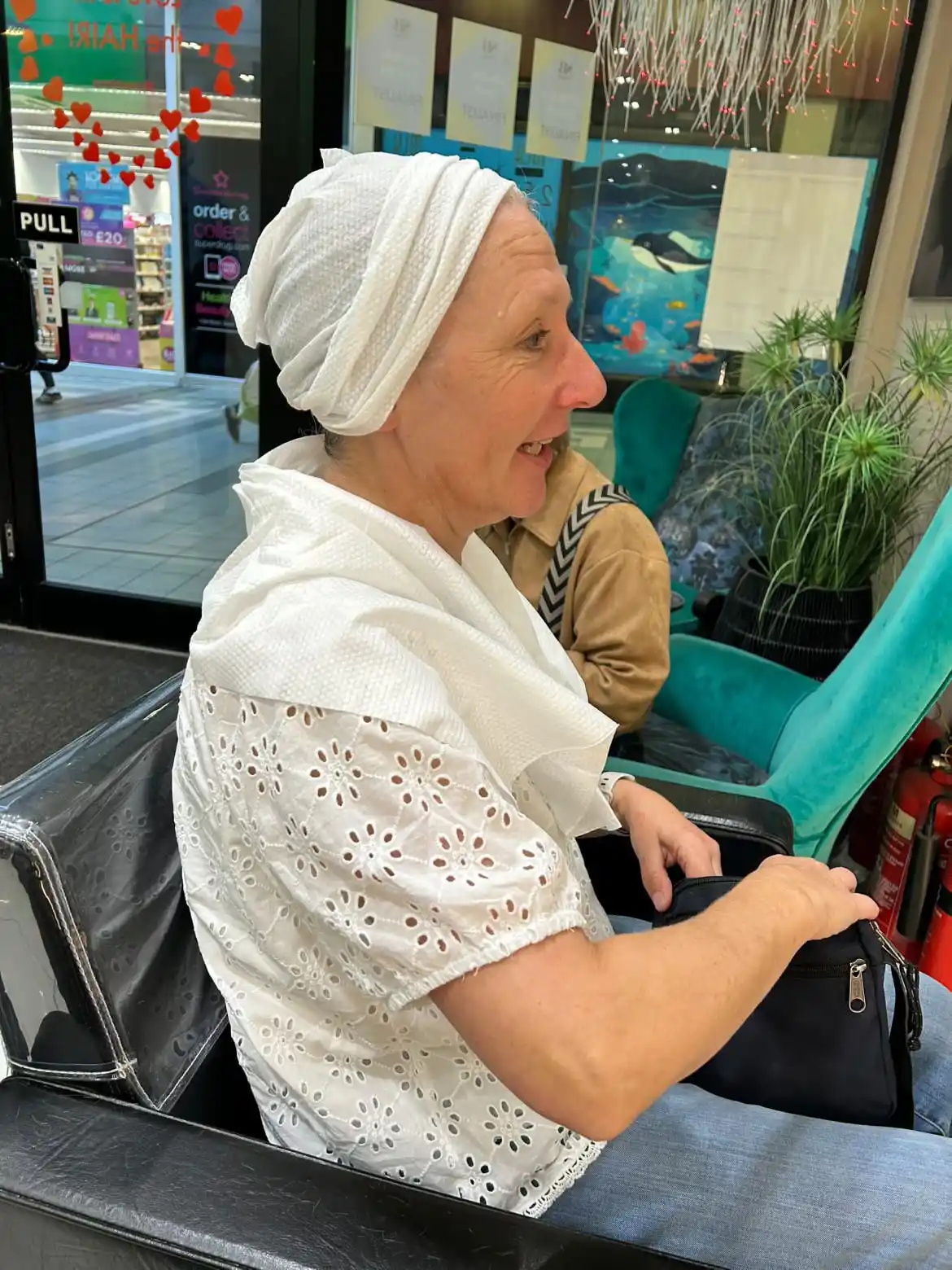 Salon client wearing a soft disposable towel head wrap during a relaxing hair treatment, showcasing a comfortable, hygienic salon experience.