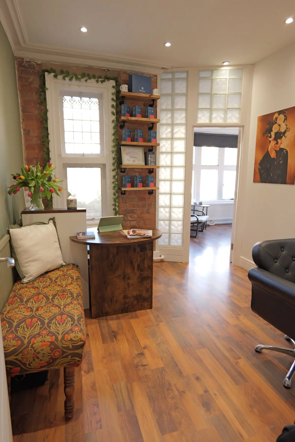 Salon waiting area and reception featuring an oak style desk.