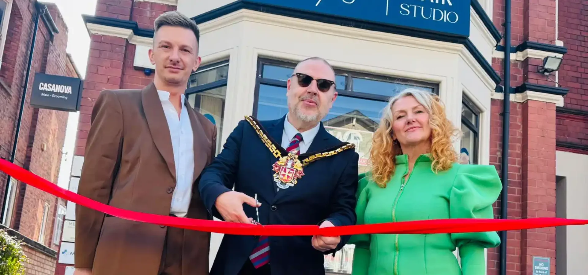 Salon members stand beside the Major as the opening rope its cut to the new salon.