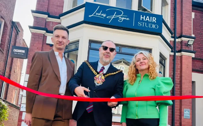 Salon members stand beside the Major as the opening rope its cut to the new salon.