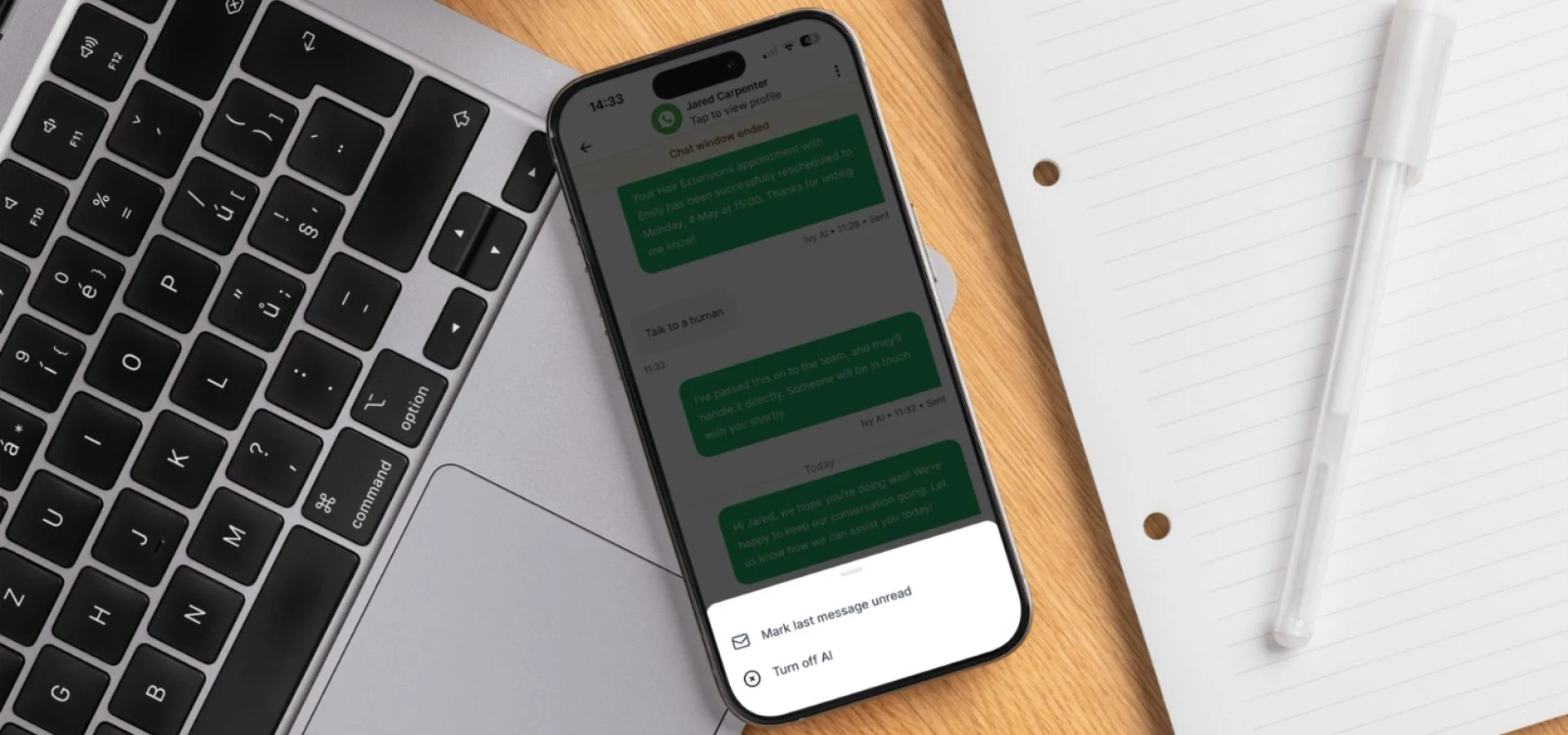 Smartphone displaying AI-powered salon messaging beside a laptop and notepad, highlighting digital client communication and automation.