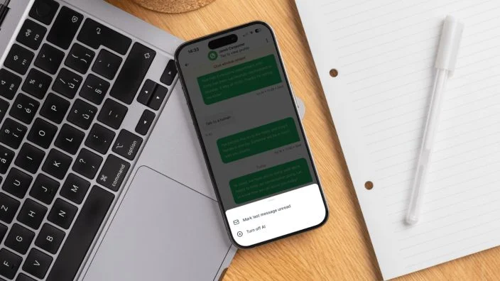 Smartphone displaying AI-powered salon messaging beside a laptop and notepad, highlighting digital client communication and automation.