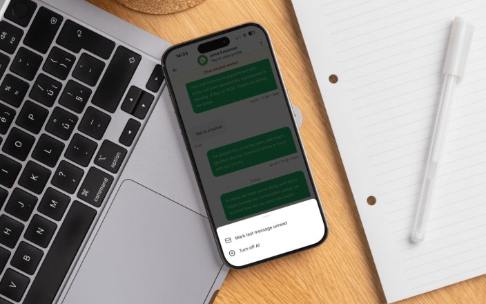 Smartphone displaying AI-powered salon messaging beside a laptop and notepad, highlighting digital client communication and automation.