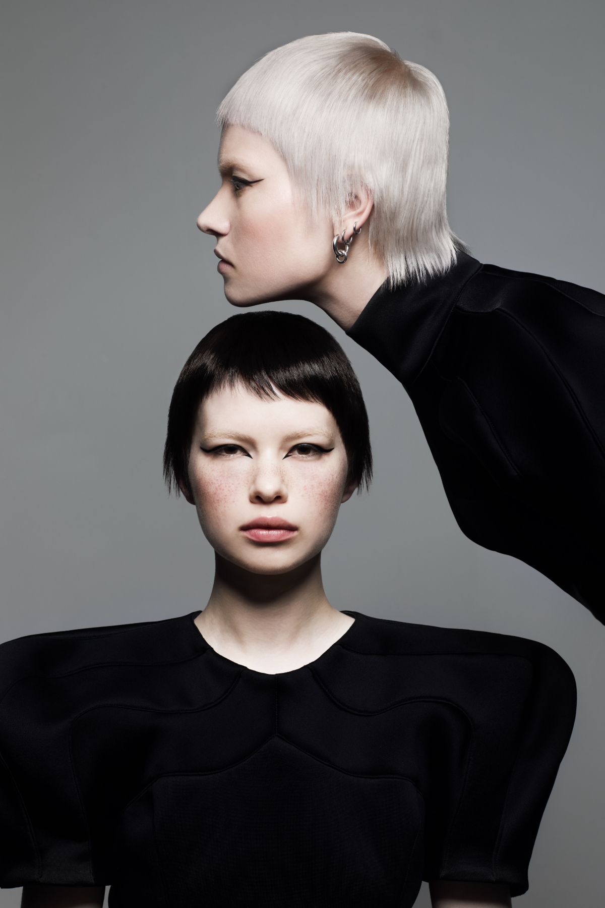 Editorial hair collection featuring sharp cropped cuts, platinum blonde and black micro fringe hairstyles on two models.