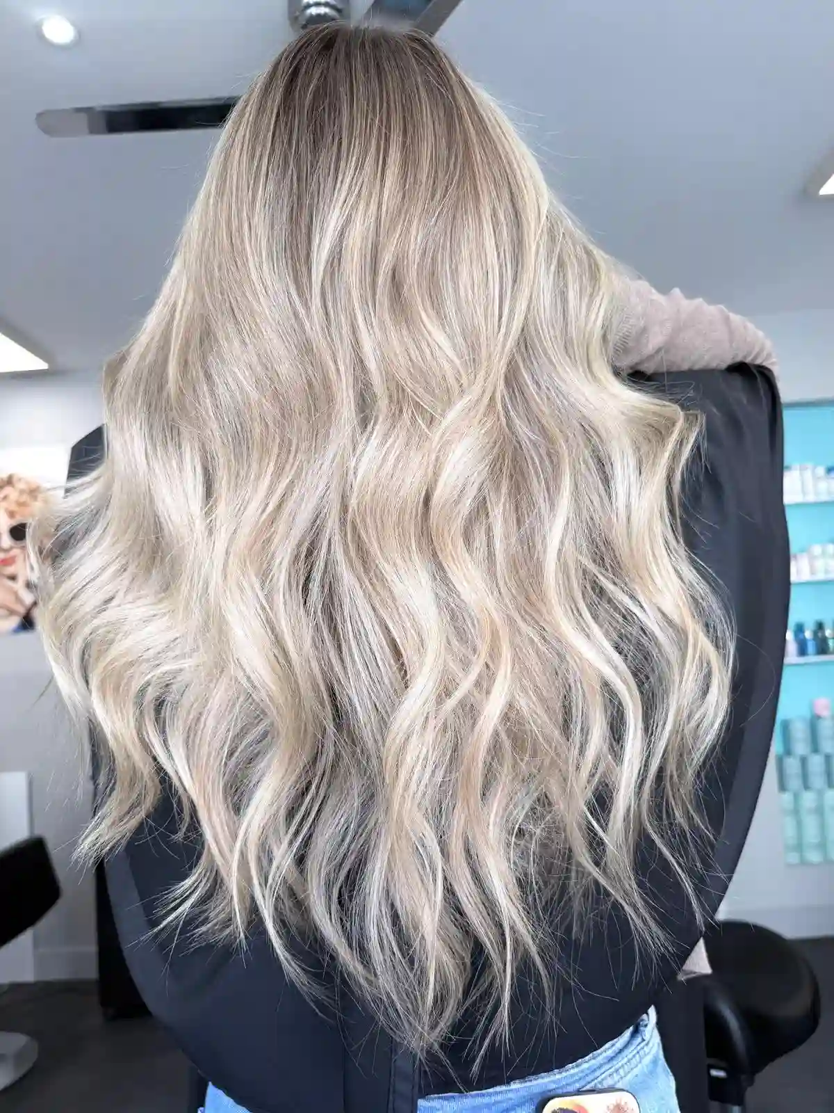 Icy platinum blonde balayage with soft beach waves and seamless root melt for a glossy, low-maintenance blonde finish.