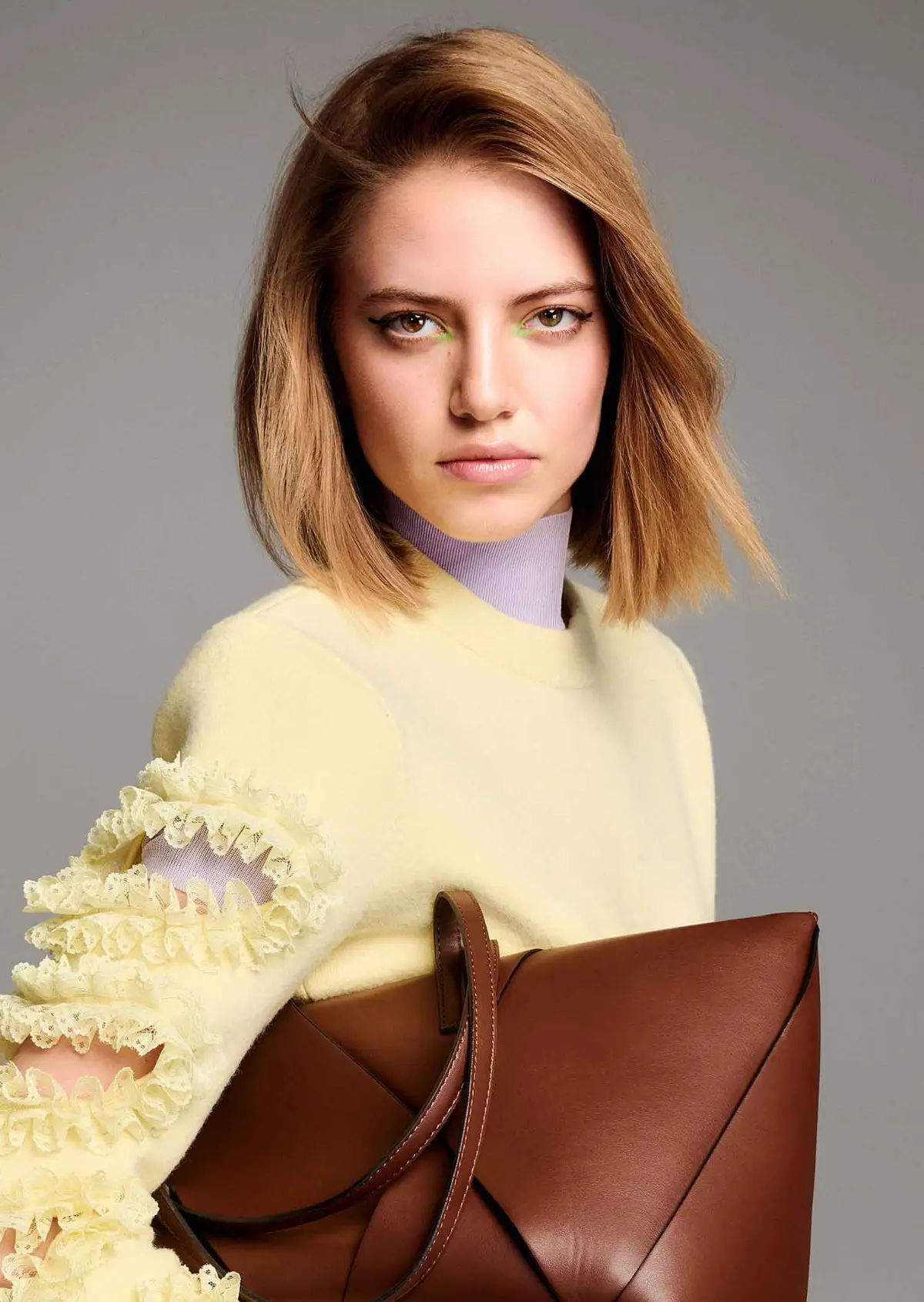 Model with glossy light brunette bob showcasing the TONI&GUY 2026 collection with a sleek, softly textured finish.