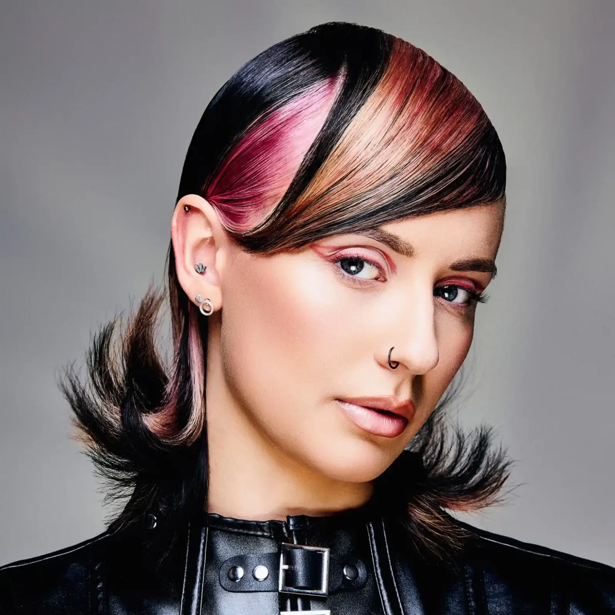 '90s-inspired sleek hairstyle with bold face-framing colour panels, flipped ends and modern editorial styling.