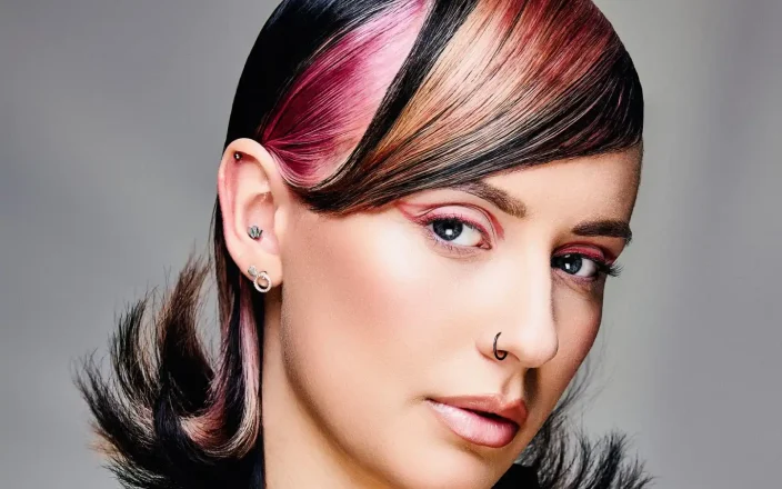 '90s-inspired sleek hairstyle with bold face-framing colour panels, flipped ends and modern editorial styling.