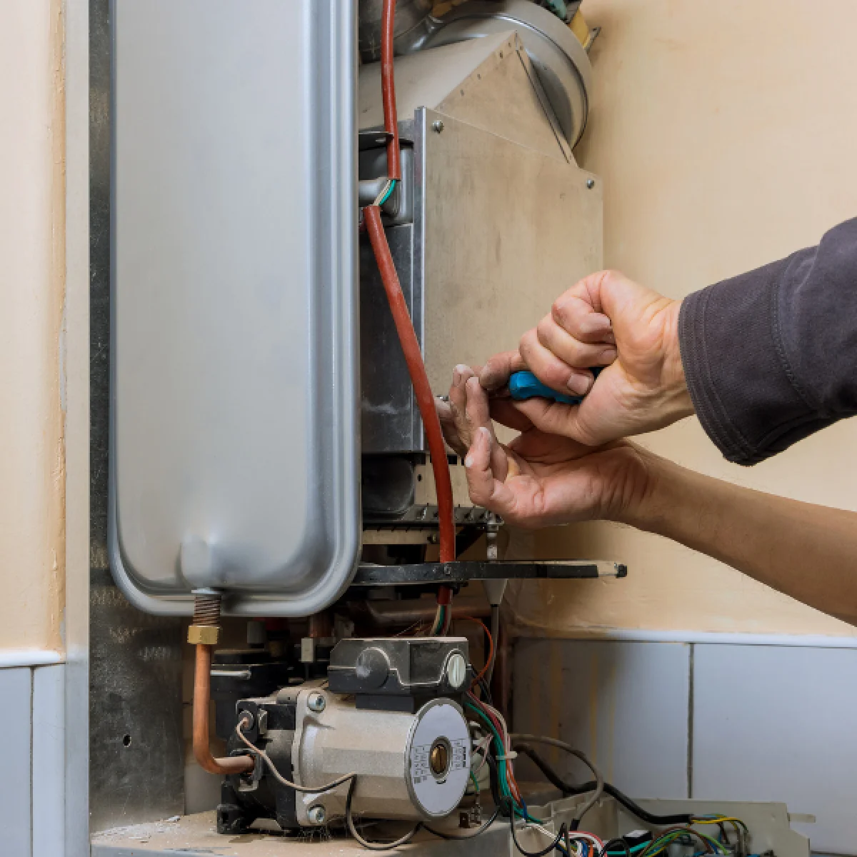 Hands fixing a boiler to highlight Alex Thaddeus's article on life lessons.