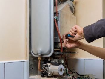 Hands fixing a boiler to highlight Alex Thaddeus's article on life lessons.