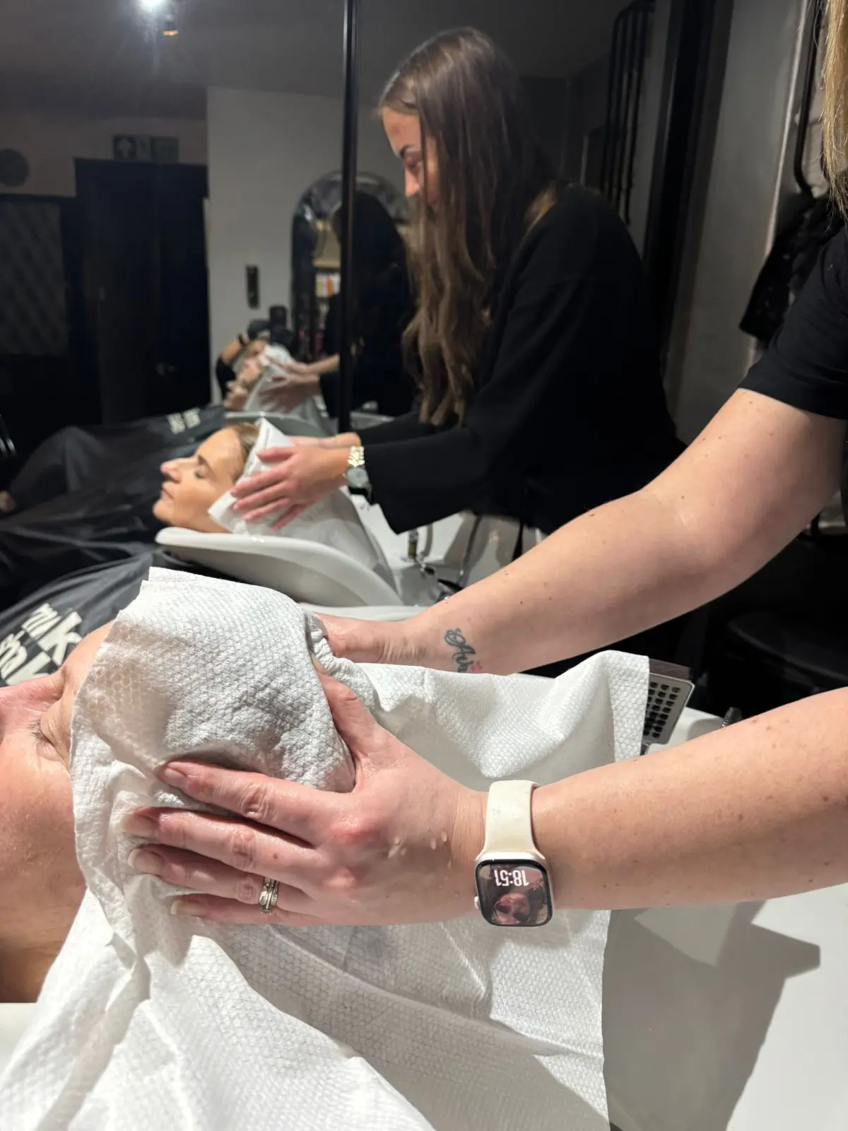 Hairdressers use Enki Towels on clients at a backwash.