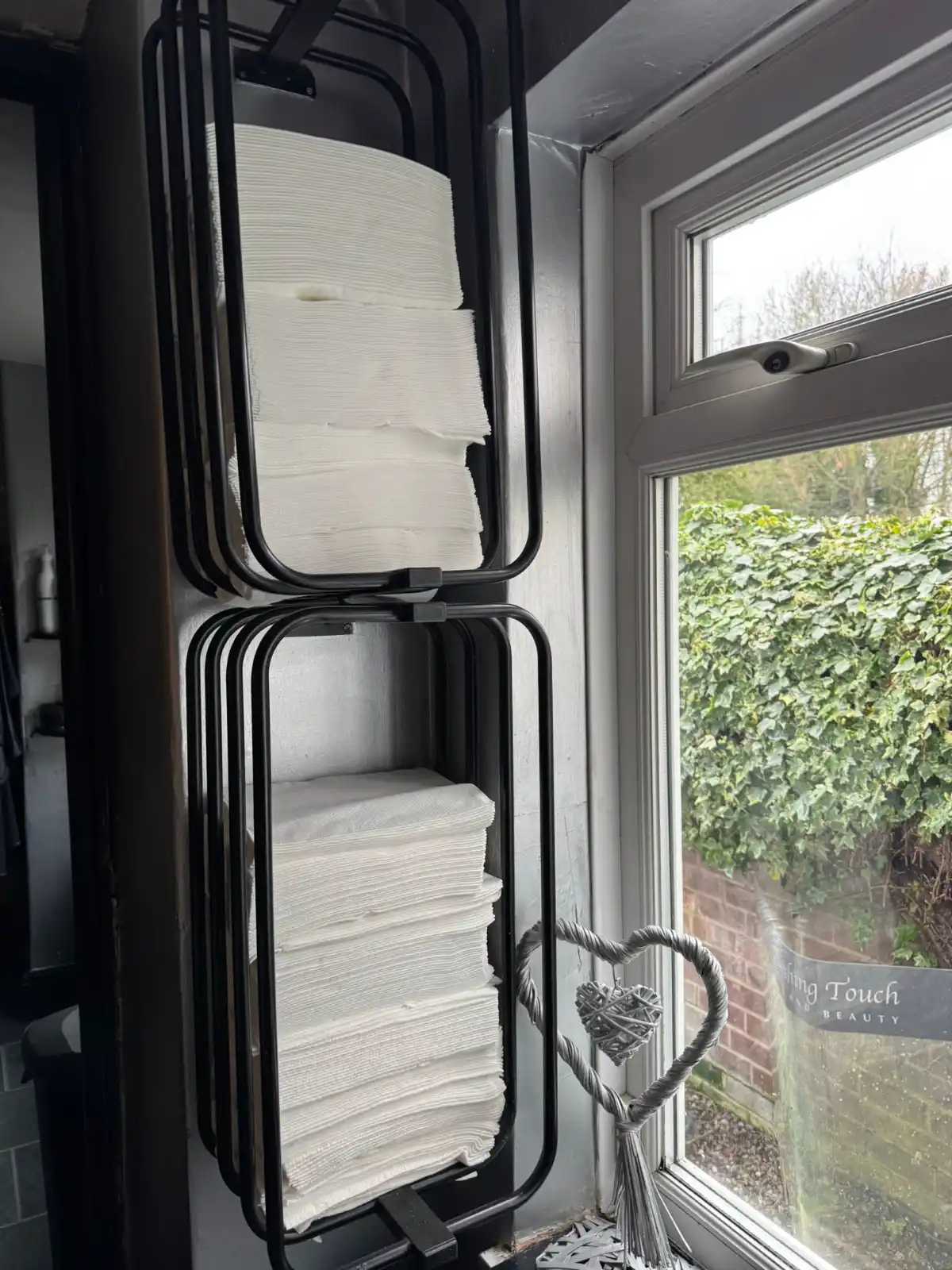 Enki single use towels displayed on a wall in a salon.
