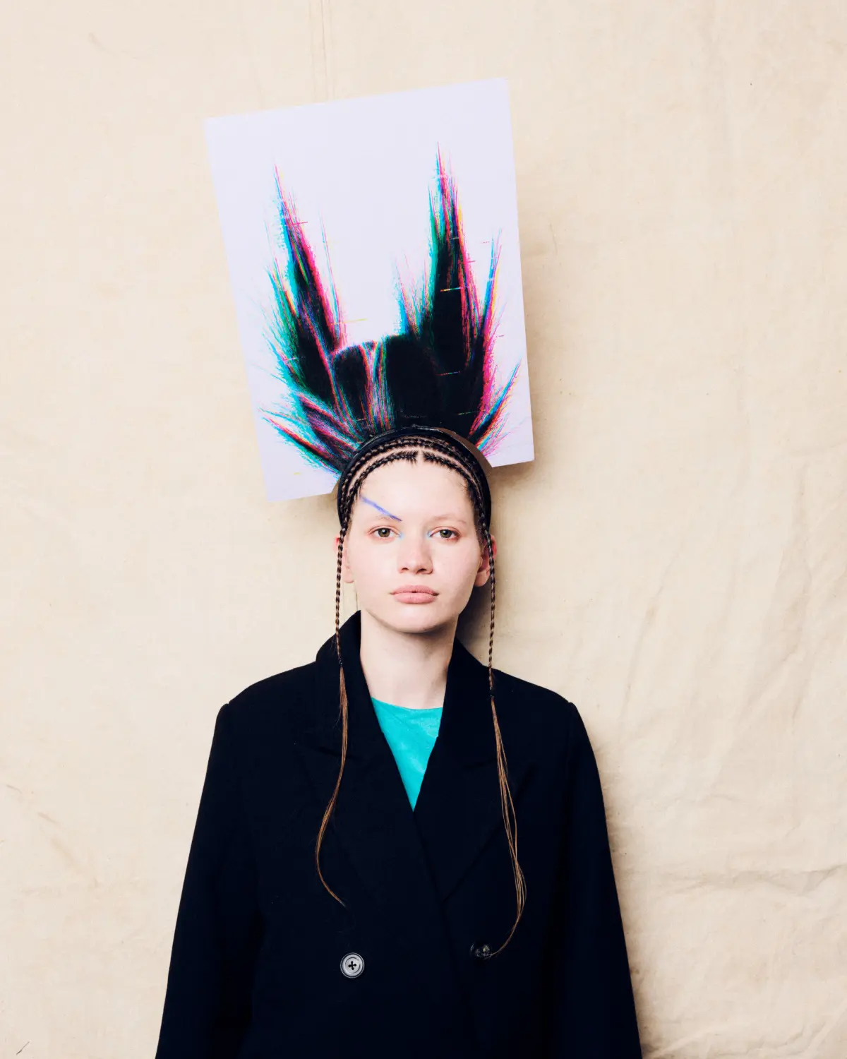 Model with avant-garde spiked hairstyle, braided details and editorial fashion styling for a creative hair collection.
