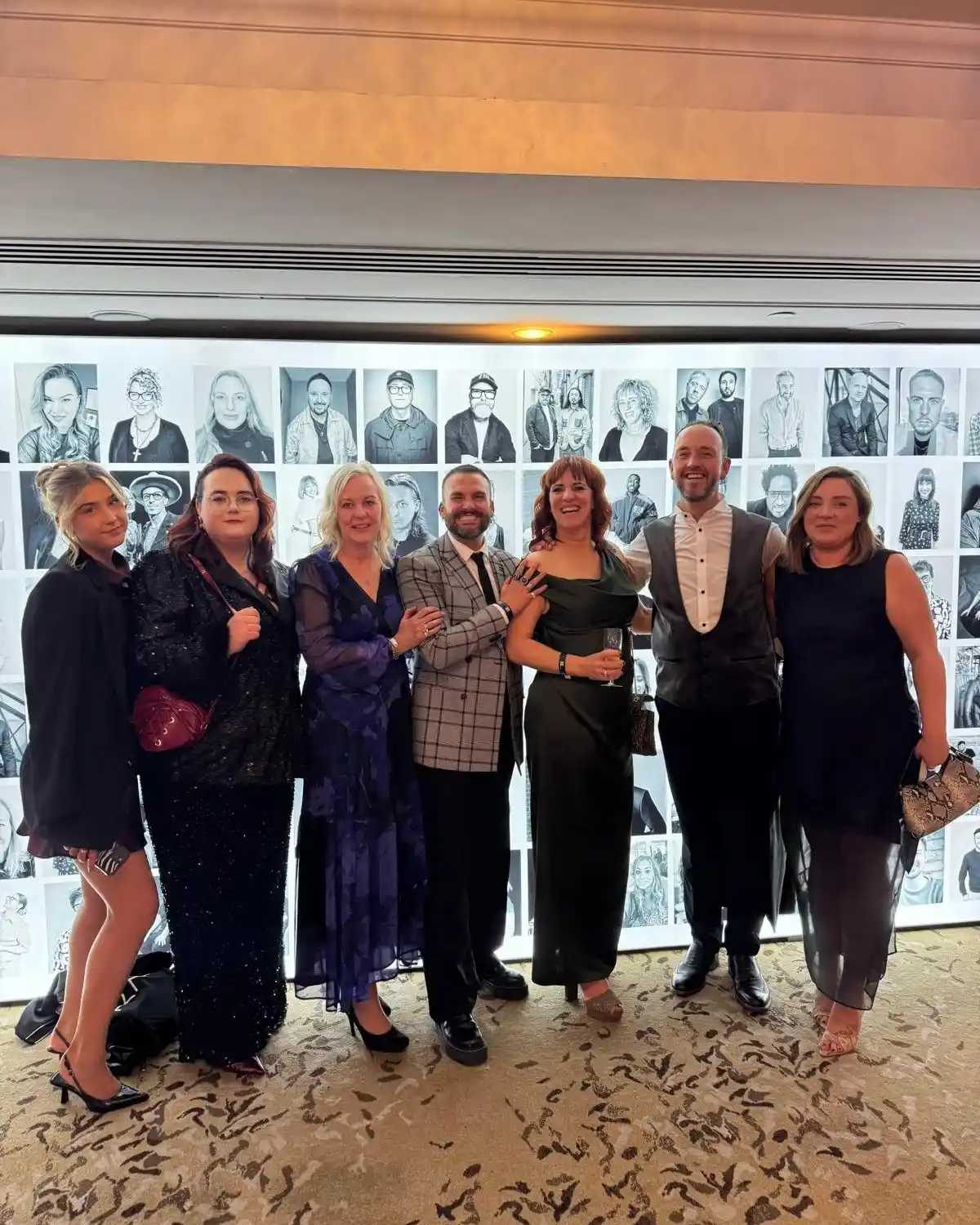 The team at KAM stand together for a photograph.