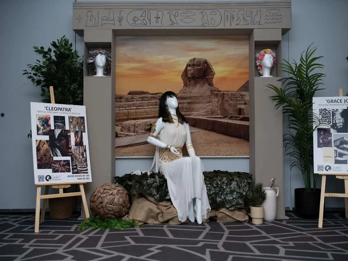 A mannequin sits in front of an Egyptian backdrop at Never Just Hair exhibition.