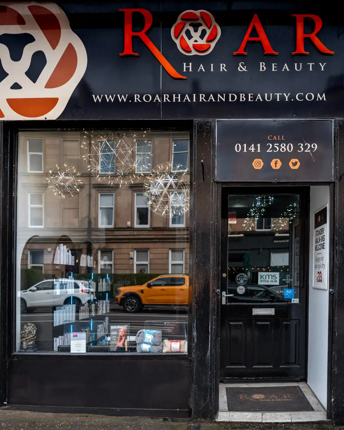 Exterior of ROAR Hair & Beauty salon with black storefront, large display window and branded entrance in Glasgow.