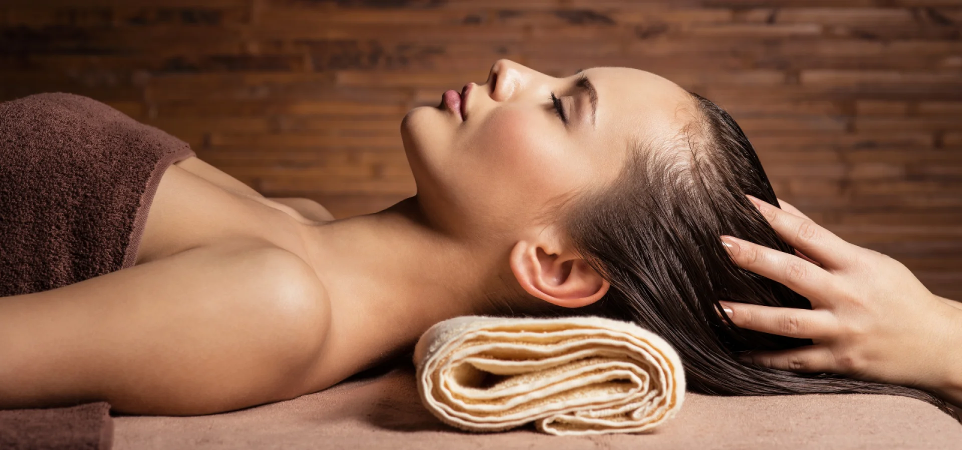 Client enjoying a relaxing head massage at a salon backwash during a luxury hair treatment focused on wellbeing.