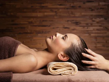 Client enjoying a relaxing head massage at a salon backwash during a luxury hair treatment focused on wellbeing.