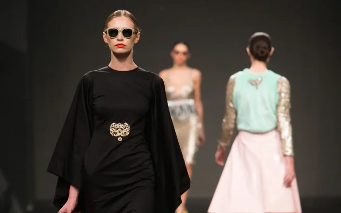 Models walk the runway during London Fashion Week, showcasing editorial hairstyles and designer fashion.
