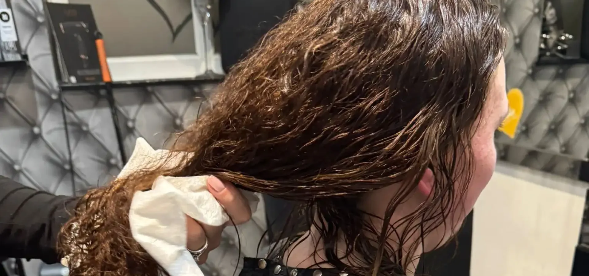 A hairdresser dries a client's hair with an Enki Towel.