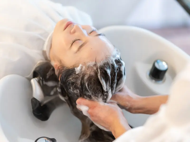 woman has hair washed at backwash