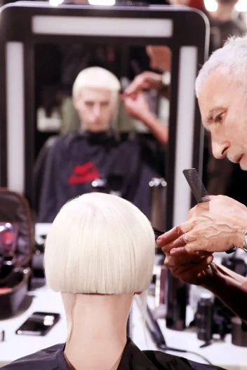 Akin Konizi cuts a model's hair in a salon.