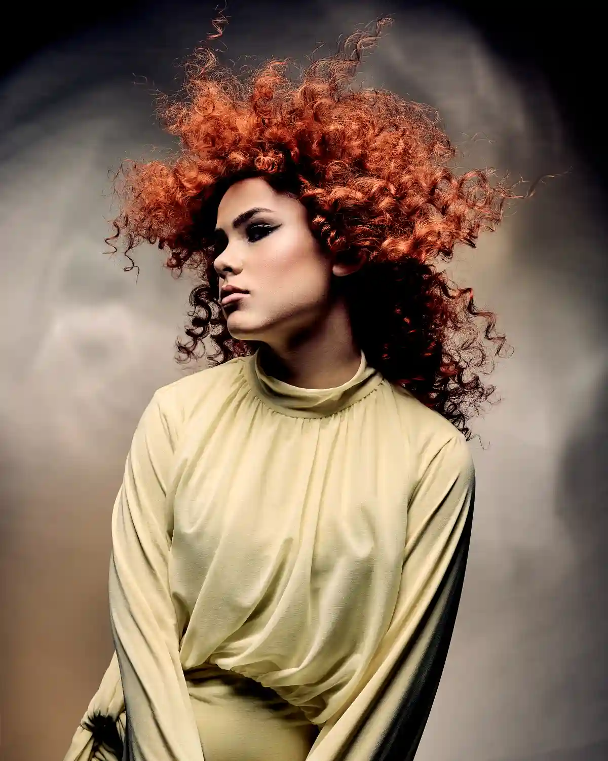 Alex Thaddeus Tempest Collection model with textured copper curls creating a dramatic, windswept hairstyle.