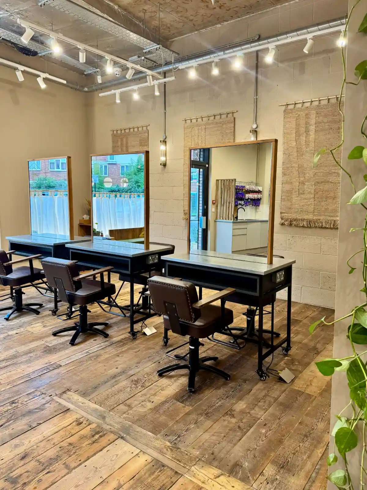 Sustainable salon interior at Butchers Salon featuring reclaimed wood flooring, natural materials, styling stations and biophilic design.