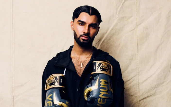 Project Men and Media’s Archetype collection featuring a model in black with gold and black Venum boxing gloves.