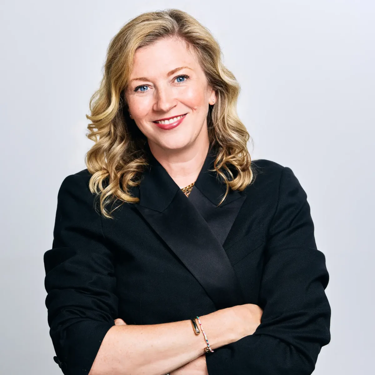 Kathleen Mitchell wears a black outfit against a white backdrop.