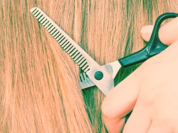 Close up of scissors cutting hair.