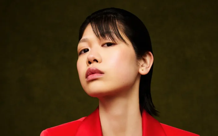 Model with short black hair in a red blazer.