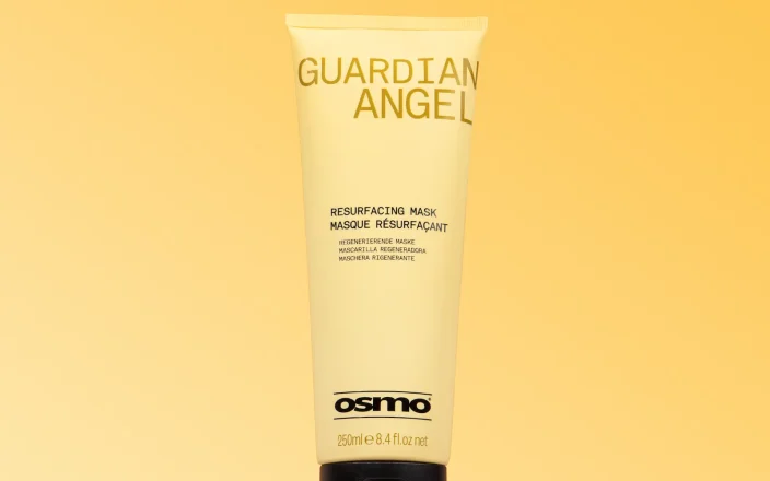 A bottle of OSMO Guardian Angel Hair Mask in branded packaging on a yellow backdrop.