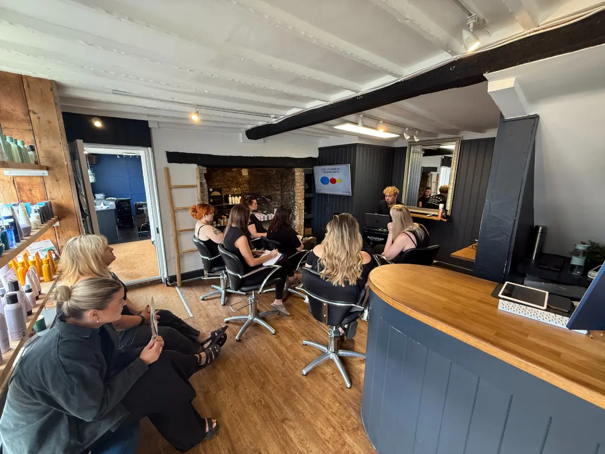 Inside the Pare Hair Salon, its team sits around watching a training demo.