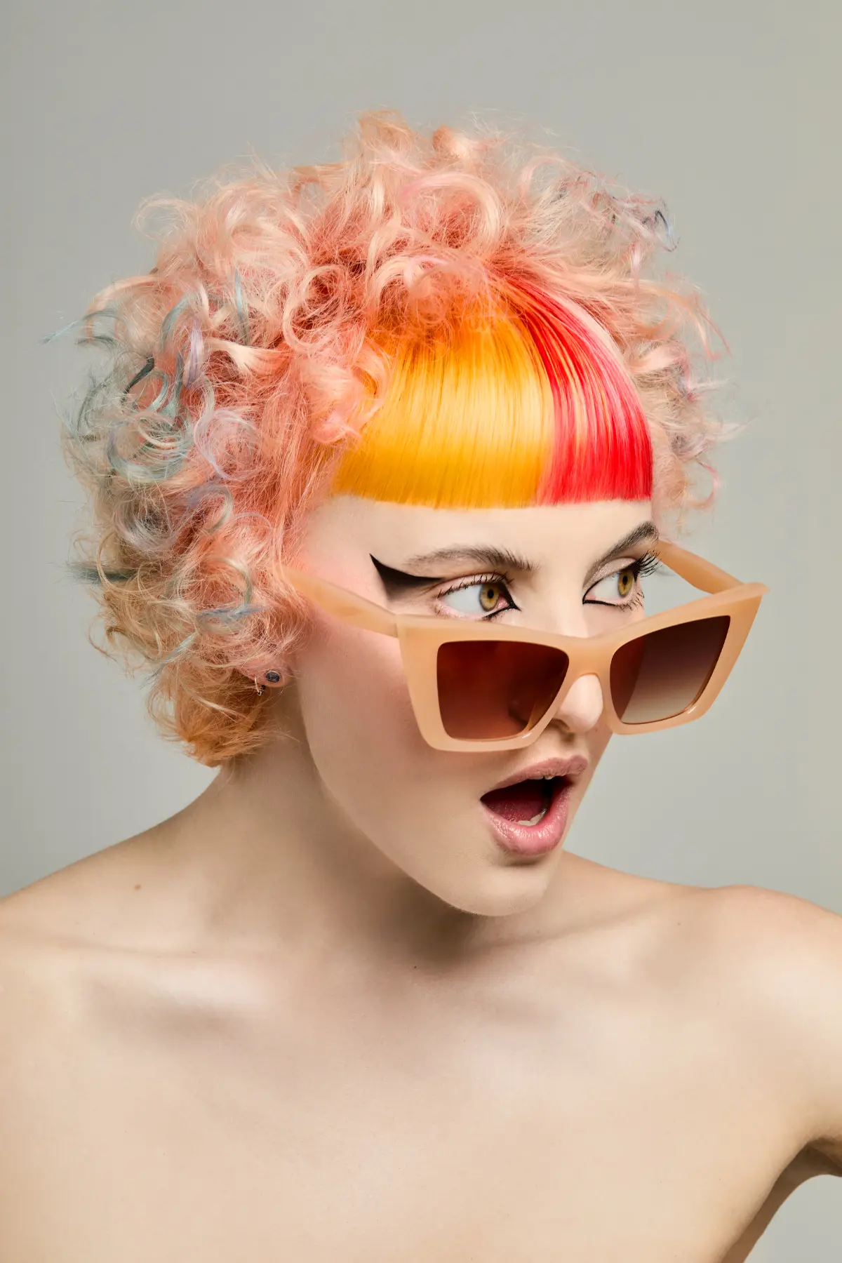 Curly pastel pixie cut with vibrant orange and red micro fringe from Roar Hair & Beauty's AW26 hair trend predictions.