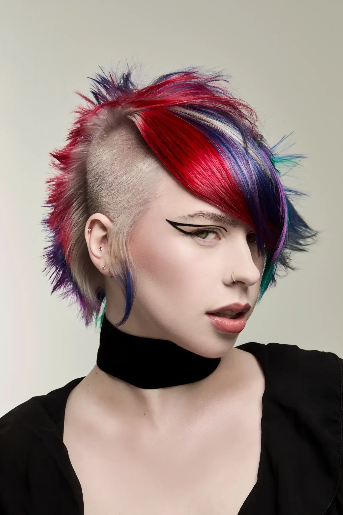 Vibrant gothic plum mullet with shaved sides and vivid red, violet and blue tones from Roar Hair & Beauty's AW26 trends.