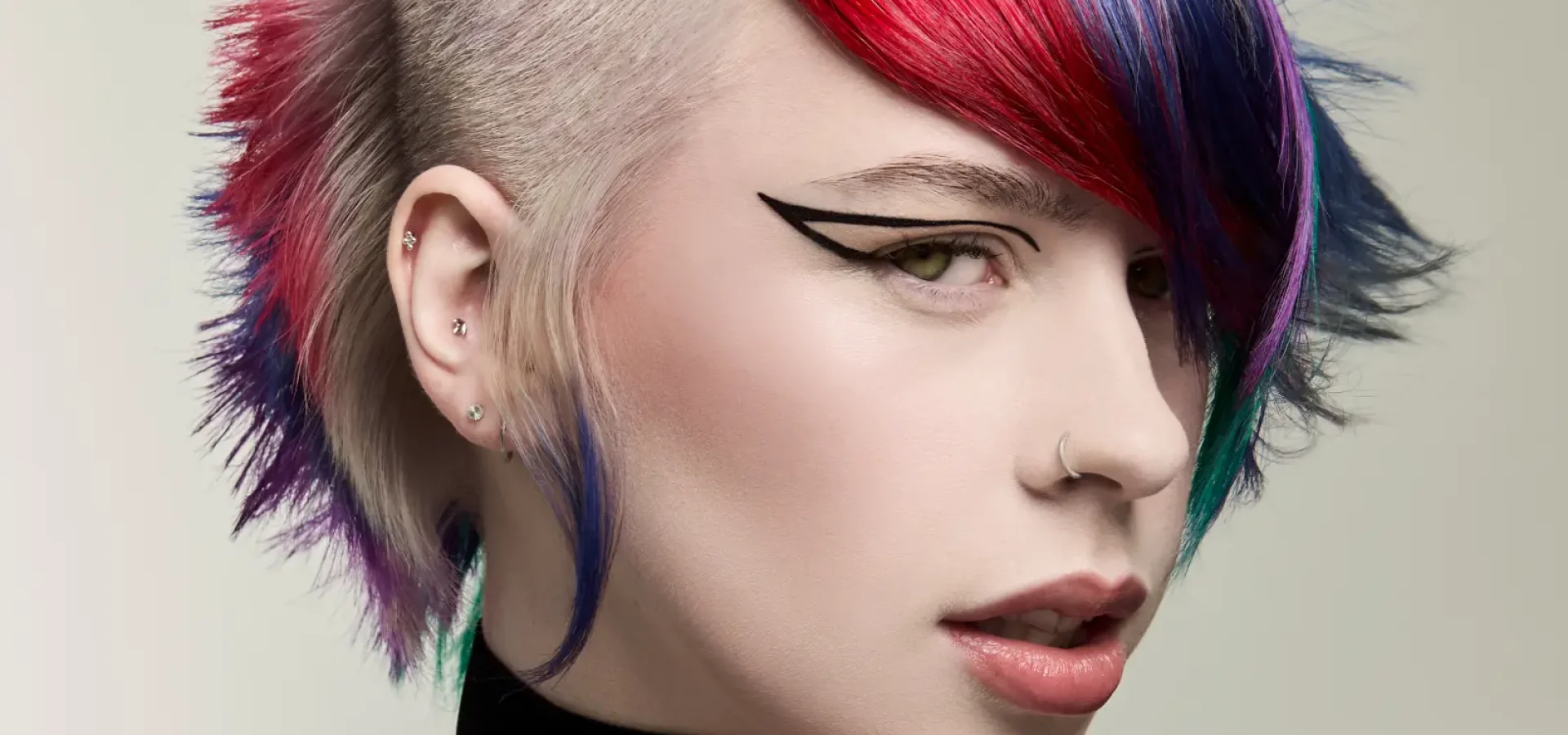 Vibrant gothic plum mullet with shaved sides and vivid red, violet and blue tones from Roar Hair & Beauty's AW26 trends.
