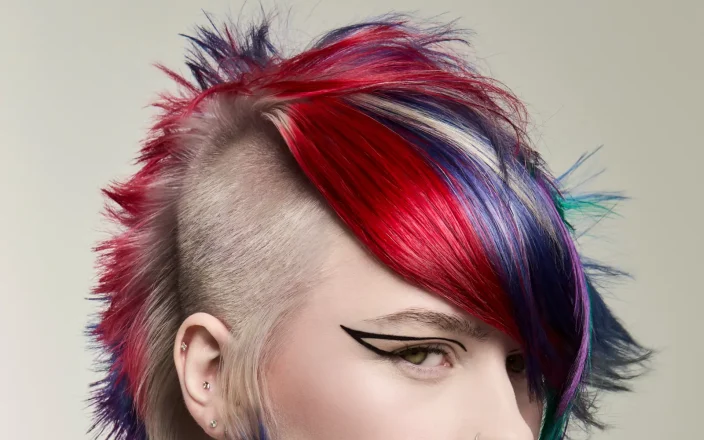 Vibrant gothic plum mullet with shaved sides and vivid red, violet and blue tones from Roar Hair & Beauty's AW26 trends.