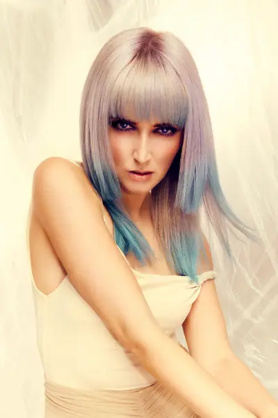 Model with a sleek silver-blonde bob hairstyle featuring blue-toned ends from the Solstice collection by Safy Burton, inspired by the shifting tones of sunrise and sunset skies with soft movement and luminous colour.