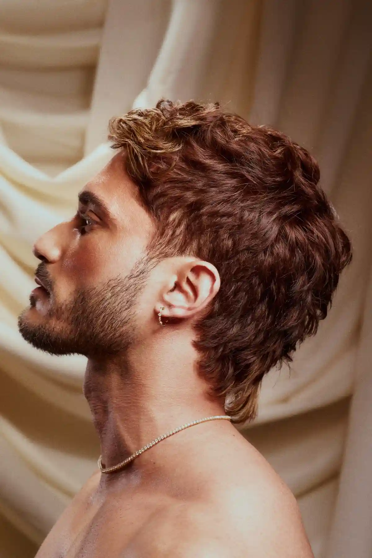 Model with short brown hair stands to the side, as part of the Archangels collection by Grant Carr.
