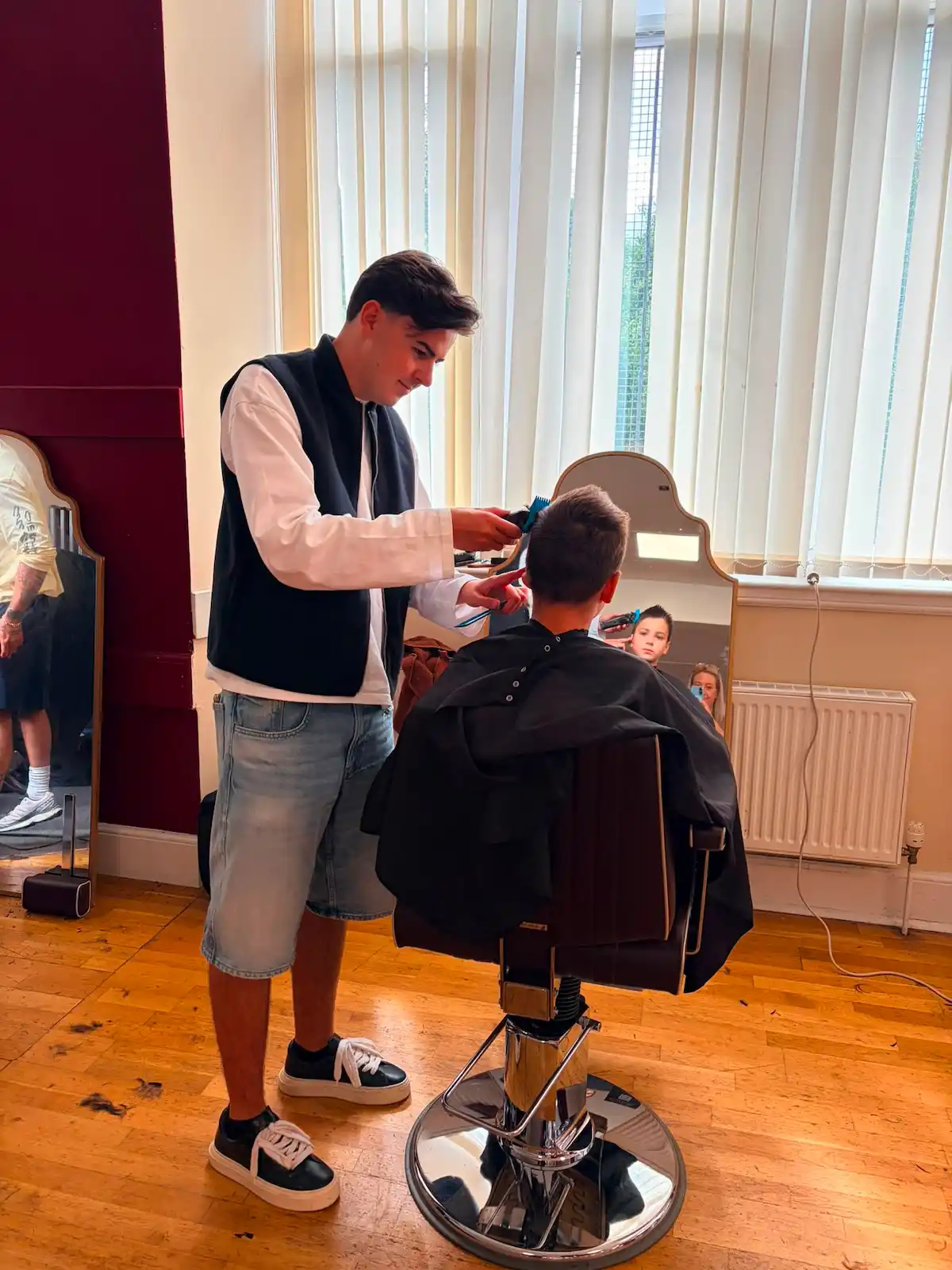 Glasgow Salon Owner Grant Carr cuts a child's hair at back to school event.
