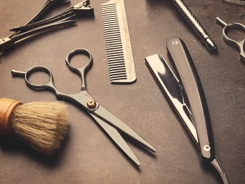 A Hairdresser's kit bag essentials on a black surface.