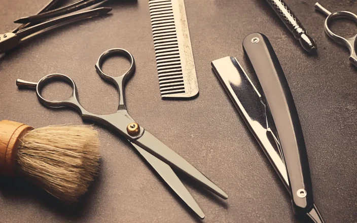 A Hairdresser's kit bag essentials on a black surface.
