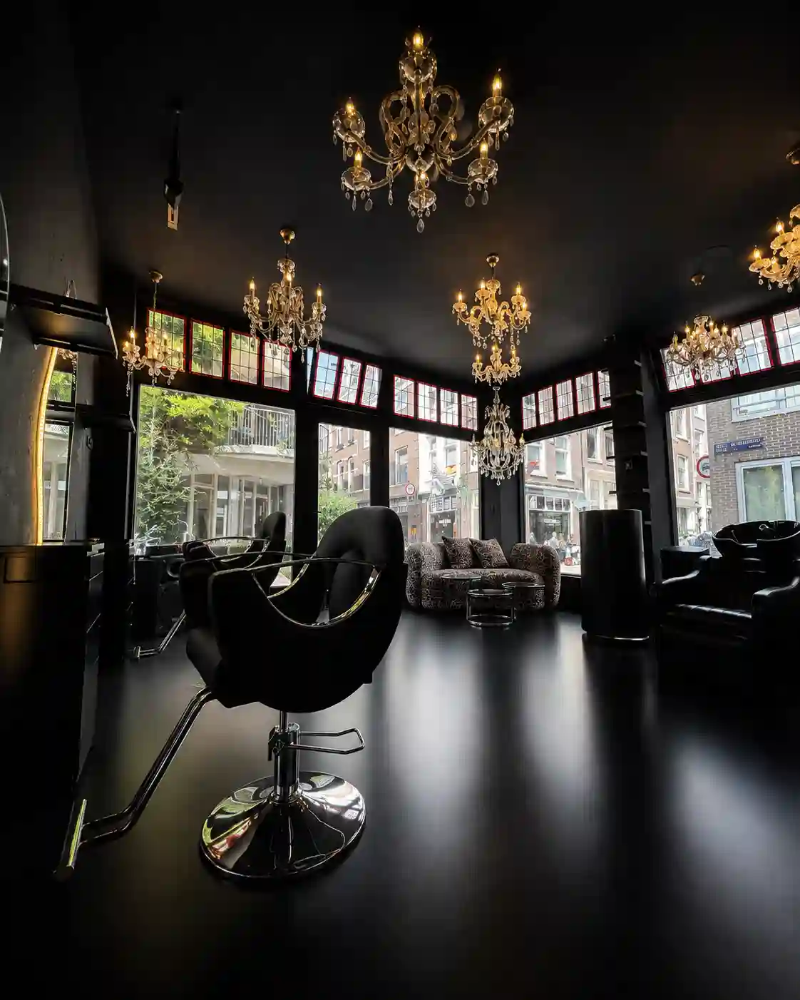 Dark mood lighting, and swivel chairs add to the interior design in Larisa Love's Amsterdam salon.